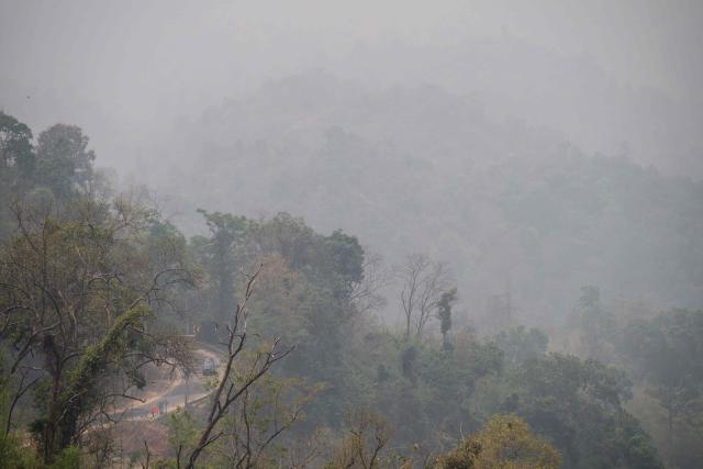 A car drives along a mountain road on a heavily polluted day in Chiang Mai on April 1, 2026. Seasonal agricultural burning, forest fires and weather patterns produce an annual pollution season across much of Southeast Asia. But parts of northern Thailand are seeing haze that even hardened locals say is exceptional. (Photo by ANTHONY WALLACE / AFP) / To go with 'Thailand-Pollution-Environment-Fire-Health' Reportage by Chayanit ITTHIPONGMAETEE