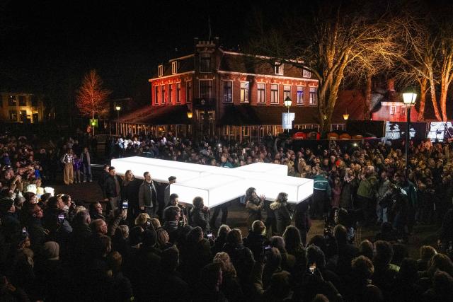 Cross-bearers attendees and spectators stand next to an illuminated cross as they take part in The Passion, a Dutch passion play, broadcasted live by the KRO-NCRV company, in Dwingeloo, The Netherlands, on April 2, 2026. (Photo by Jilmer Postma / ANP / AFP) / Netherlands OUT