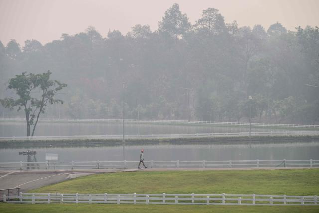 A man walks in a public park on a heavily polluted day in Chiang Mai on April 1, 2026. Seasonal agricultural burning, forest fires and weather patterns produce an annual pollution season across much of Southeast Asia. But parts of northern Thailand are seeing haze that even hardened locals say is exceptional. (Photo by ANTHONY WALLACE / AFP) / To go with 'Thailand-Pollution-Environment-Fire-Health' Reportage by Chayanit ITTHIPONGMAETEE