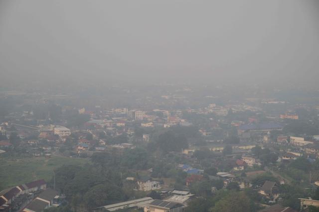 Thick pollution is seen from a passenger airline window shortly before landing in Chiang Mai on April 1, 2026. Seasonal agricultural burning, forest fires and weather patterns produce an annual pollution season across much of Southeast Asia. But parts of northern Thailand are seeing haze that even hardened locals say is exceptional. (Photo by ANTHONY WALLACE / AFP) / To go with 'Thailand-Pollution-Environment-Fire-Health' Reportage by Chayanit ITTHIPONGMAETEE
