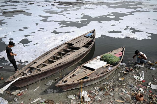 Children search for usable items on the banks of the river Yamuna laden with toxic foam in New Delhi on April 3, 2026. (Photo by Arun SANKAR / AFP)