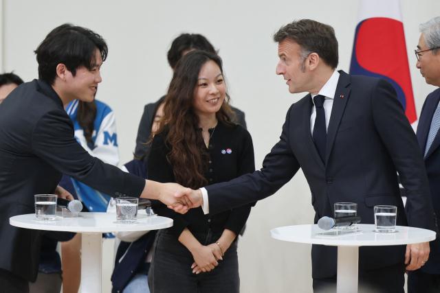 French President Emmanuel Macron (R) attends a meeting with students at Yonsei University in Seoul on April 3, 2026. (Photo by Ludovic MARIN / AFP)