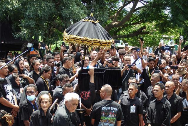 Catholic devotees carry a casket containing a statue of Jesus during a Good Friday sea procession from Tuan Menino Chapel, a ritual inherited from Portuguese influence for over five centuries, in Larantuka, East Nusa Tenggara, on April 3, 2026. (Photo by ARNOLD WELIANTO / AFP)