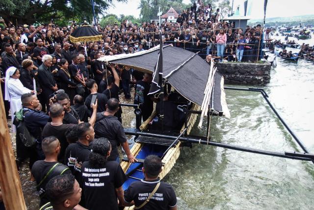 Catholic devotees transport a casket containing a statue of Jesus by boat during a Good Friday sea procession from Tuan Menino Chapel, a ritual inherited from Portuguese influence for over five centuries, in Larantuka, East Nusa Tenggara, on April 3, 2026. (Photo by ARNOLD WELIANTO / AFP)