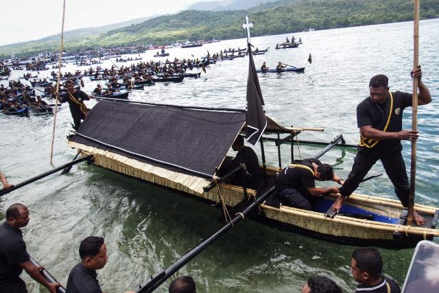 Catholic devotees transport a casket containing a statue of Jesus by boat during a Good Friday sea procession from Tuan Menino Chapel, a ritual inherited from Portuguese influence for over five centuries, in Larantuka, East Nusa Tenggara, on April 3, 2026. (Photo by ARNOLD WELIANTO / AFP)