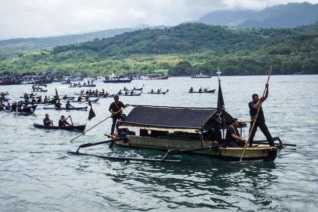 TOPSHOT - Catholic devotees transport a casket containing a statue of Jesus by boat during a Good Friday sea procession from Tuan Menino Chapel, a ritual inherited from Portuguese influence for over five centuries, in Larantuka, East Nusa Tenggara, on April 3, 2026. (Photo by ARNOLD WELIANTO / AFP)