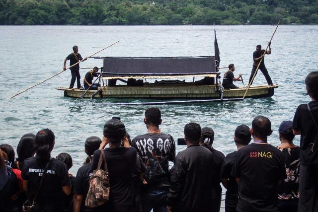 Catholic devotees transport a casket containing a statue of Jesus by boat during a Good Friday sea procession from Tuan Menino Chapel, a ritual inherited from Portuguese influence for over five centuries, in Larantuka, East Nusa Tenggara, on April 3, 2026. (Photo by ARNOLD WELIANTO / AFP)