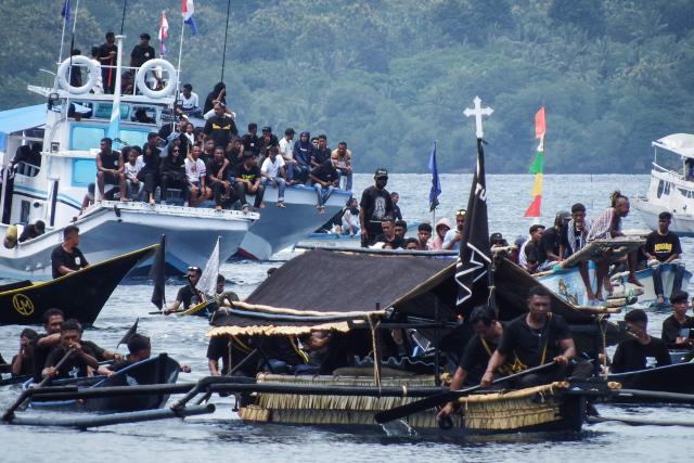 Catholic devotees transport a casket containing a statue of Jesus by boat during a Good Friday sea procession from Tuan Menino Chapel, a ritual inherited from Portuguese influence for over five centuries, in Larantuka, East Nusa Tenggara, on April 3, 2026. (Photo by ARNOLD WELIANTO / AFP)