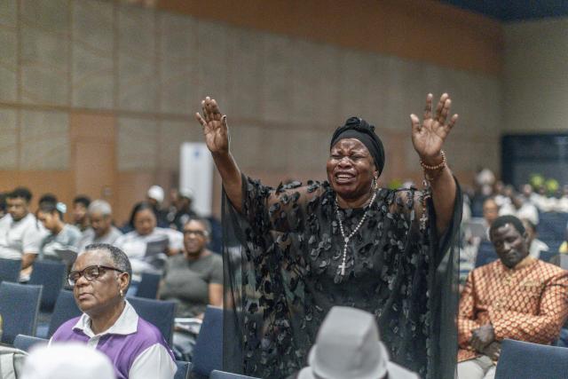 A woman gestures during the Good Friday prayer at the International Convention Centre (ICC) in Durban on April 3, 2026. (Photo by RAJESH JANTILAL / AFP)