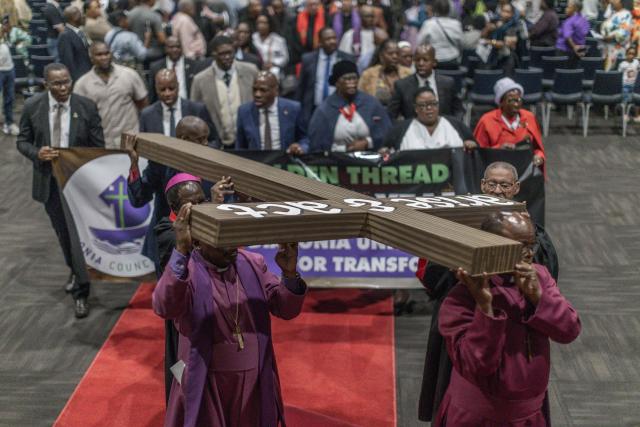 Clergymen from different Christian denominations carry a wooden cross from the International Convention Centre (ICC) during the Good Friday procession to the Durban City Hall in Durban on April 3, 2026. (Photo by RAJESH JANTILAL / AFP)