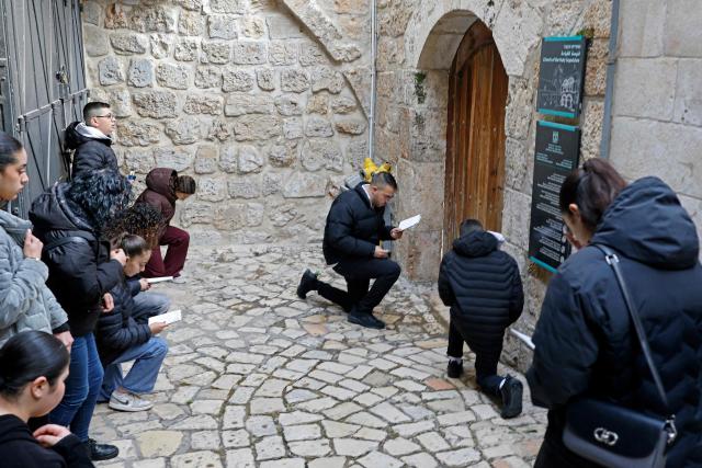 Christian pilgrims pray in front of the closed door of Church of the Holy Sepulchre in the Old City of Jerusalem on April 3, 2026. Holy sites in Jerusalem's old city have remained closed for security reasons since the outbreak of the Middle East war on February 28, when Israel and the US launched strikes on Iran. (Photo by Marco Longari / AFP)