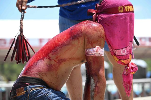EDITORS NOTE: Graphic content / A penitent kneels in front of the crosses prior to the annual crucifixion during the observance of Lent in the village of Cutud in San Fernando, Pampanga province on April 3, 2026. Devotees in the fervently Catholic Philippines marked Good Friday by being nailed to crosses and whipping their backs bloody, in extreme acts of devotion that attracted thousands of spectators. (Photo by Ted ALJIBE / AFP)