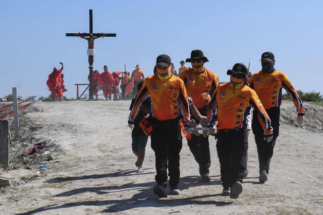 EDITORS NOTE: Graphic content / Medical responders carry a penitent on a stretcher who was nailed to a cross during the annual crucifixion as part of the observance of Lent in the village of Cutud in San Fernando, Pampanga province on April 3, 2026. Devotees in the fervently Catholic Philippines marked Good Friday by being nailed to crosses and whipping their backs bloody, in extreme acts of devotion that attracted thousands of spectators. (Photo by Ted ALJIBE / AFP)