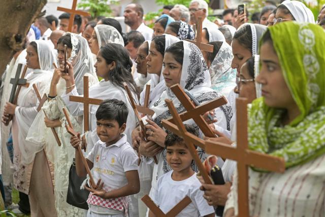Christians bearing crosses take part in a Good Friday procession in Amritsar on April 3, 2026. (Photo by Narinder NANU / AFP)