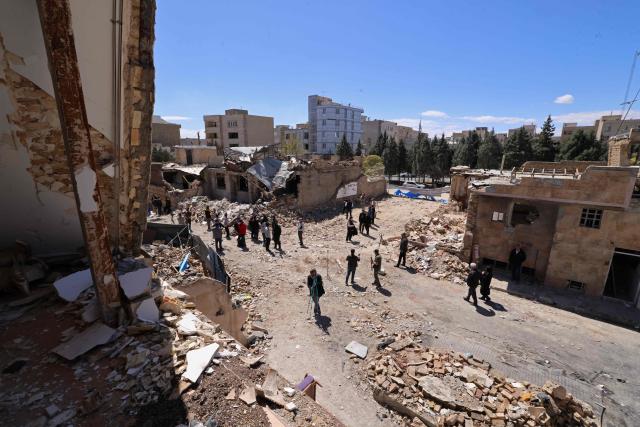 Media representatives gather around residential buildings that were damaged by recent strikes at Vahdat town in Karaj, southwest of Tehran on April 3, 2026. Iran and its allies traded fire with Israel and the United States, as Washington-linked assets across the Middle East were targeted alongside civilian infrastructure -- with the month-long war on April 3 showing little sign of easing. (Photo by ATTA KENARE / AFP) / 