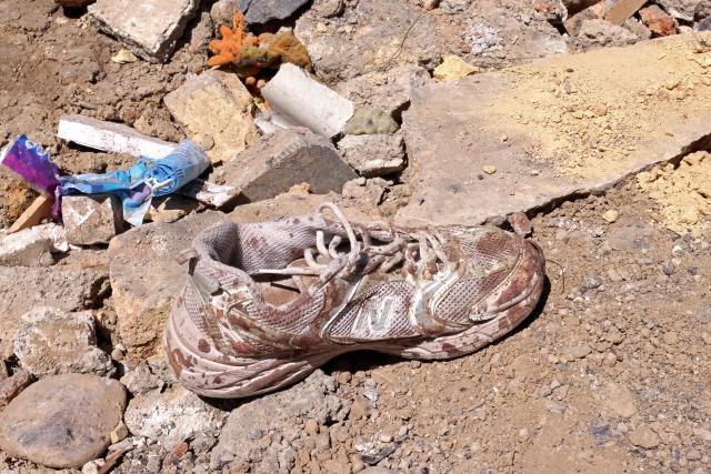 A blood stained shoe lies amid the debris of a residential building that was damaged by recent strikes at Vahdat town in Karaj, southwest of Tehran on April 3, 2026. Iran and its allies traded fire with Israel and the United States, as Washington-linked assets across the Middle East were targeted alongside civilian infrastructure -- with the month-long war on April 3 showing little sign of easing. (Photo by ATTA KENARE / AFP) / 