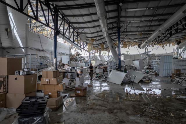 A man assesses the damage at a factory that got hit by a missile in Petah Tikva, east of Tel Aviv, on April 3, 2026. Israel said it was under attack from a new barrage of Iranian missiles, as US President Donald Trump warned Washington had yet to begin "destroying what's left" of Iran's infrastructure. The war started more than a month ago with US-Israeli strikes on Iran, triggering retaliation that spread the conflict throughout the Middle East, convulsing the global economy and impacting millions of people worldwide. (Photo by Ilia YEFIMOVICH / AFP) / 