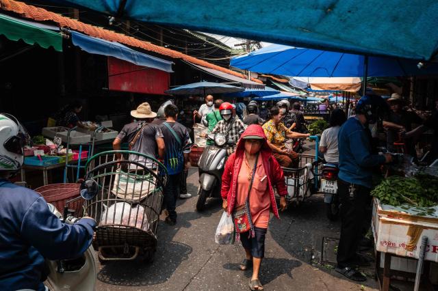 People wear face masks as they visit a market on a heavily polluted day in Chiang Mai on April 2, 2026. (Photo by ANTHONY WALLACE / AFP)