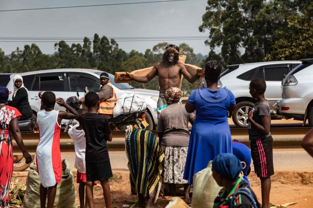 People react to Ugandan skater John Talasinga as he reenacts Jesus' Via Crucis (Way of the Cross) on his skates on Good Friday in Wakiso on April 3, 2026. (Photo by BADRU KATUMBA / AFP)