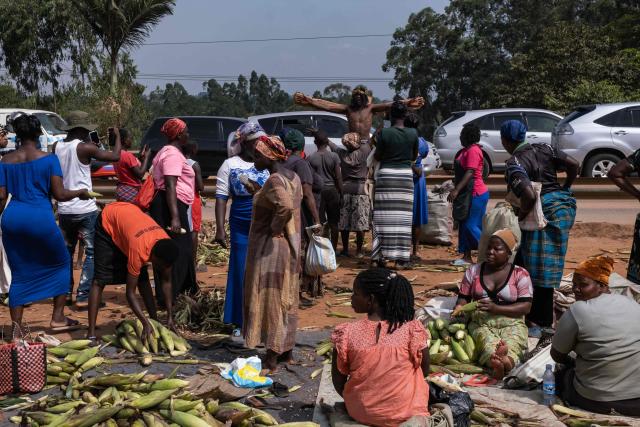 People react to Ugandan skater John Talasinga as he reenacts Jesus' Via Crucis (Way of the Cross) on his skates on Good Friday in Wakiso on April 3, 2026. (Photo by BADRU KATUMBA / AFP)