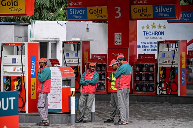 Workers wait for customers at a fuel station after the government raised fuel prices in Islamabad on April 3, 2026. State-run public transport in Pakistan's capital and most populous province will be free for the coming month, officials said on April 3, after the government drastically raised fuel prices due to spiking global energy prices caused by the Iran war. (Photo by Farooq NAEEM / AFP)