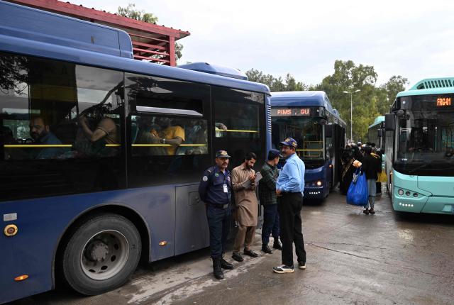 Passengers sit in a government bus at a stop in Islamabad on April 3, 2026. State-run public transport in Pakistan's capital and most populous province will be free for the coming month, officials said on April 3, after the government drastically raised fuel prices due to spiking global energy prices caused by the Iran war. (Photo by Farooq NAEEM / AFP)