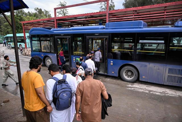 Passengers queue to board a government bus at a bus stop in Islamabad on April 3, 2026. State-run public transport in Pakistan's capital and most populous province will be free for the coming month, officials said on April 3, after the government drastically raised fuel prices due to spiking global energy prices caused by the Iran war. (Photo by Farooq NAEEM / AFP)