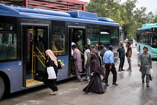 Passengers board a government bus at a bus stop in Islamabad on April 3, 2026. State-run public transport in Pakistan's capital and most populous province will be free for the coming month, officials said on April 3, after the government drastically raised fuel prices due to spiking global energy prices caused by the Iran war. (Photo by Farooq NAEEM / AFP)