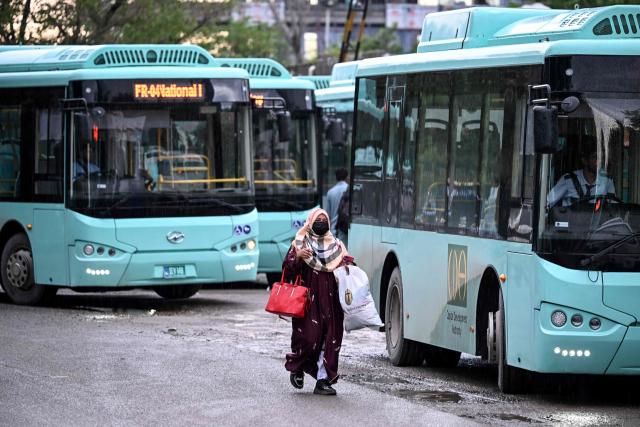 A woman passenger arrives at a government bus stop in Islamabad on April 3, 2026. State-run public transport in Pakistan's capital and most populous province will be free for the coming month, officials said on April 3, after the government drastically raised fuel prices due to spiking global energy prices caused by the Iran war. (Photo by Farooq NAEEM / AFP)