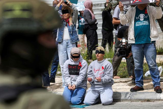 Israeli security forces stand before protesters gathering for a demonstration organised by the Israeli and Palestinian "Combatants for Peace" movement, against the recently-approved law allowing the execution of Palestinians convicted on terror charges for deadly attacks, at the Beit Jala North junction in the occupied West Bank on April 3, 2026. Under the new law, passed in parliament late on March 30, Palestinians in the West Bank convicted by military courts of carrying out deadly attacks classified as "terrorism" will face the death penalty as a default sentence. Because Palestinians in the territory are automatically tried in Israeli military courts, the measure effectively creates a separate and harsher legal track. (Photo by HAZEM BADER / AFP)