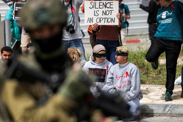 Israeli security forces stand before protesters gathering for a demonstration organised by the Israeli and Palestinian "Combatants for Peace" movement, against the recently-approved law allowing the execution of Palestinians convicted on terror charges for deadly attacks, at the Beit Jala North junction in the occupied West Bank on April 3, 2026. Under the new law, passed in parliament late on March 30, Palestinians in the West Bank convicted by military courts of carrying out deadly attacks classified as "terrorism" will face the death penalty as a default sentence. Because Palestinians in the territory are automatically tried in Israeli military courts, the measure effectively creates a separate and harsher legal track. (Photo by HAZEM BADER / AFP)