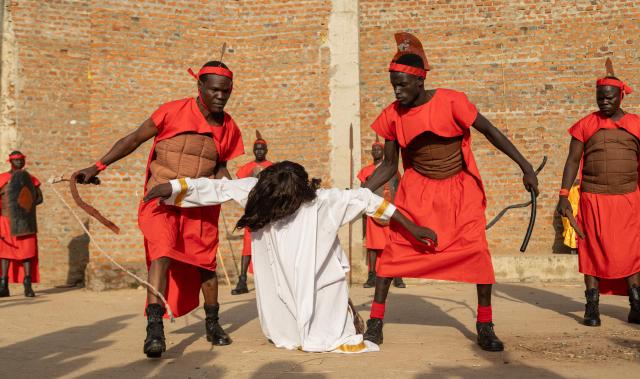 Participants dressed as Roman soldiers handle a man portraying Jesus Christ during a reenactment of the crucifixion at a Good Friday procession in Juba, South Sudan on April 3, 2026. The joint church event commemorated the crucifixion of Jesus Christ and included prayers for peace in South Sudan. (Photo by Isaac Buay / AFP)