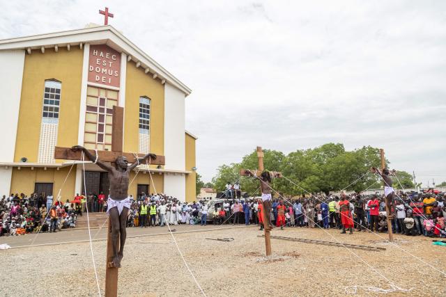 Three participants portraying Jesus Christ (C) and the two thieves hang on crosses during a reenactment of the crucifixion at St. Theresa Cathedral Kator in Juba, South Sudan on April 3, 2026. The joint church event commemorated the crucifixion of Jesus Christ and included prayers for peace in South Sudan. (Photo by Isaac Buay / AFP)