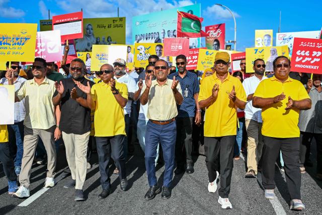 Maldives’ former presidents and leaders of the Maldivian Democratic Party (MDP), Ibrahim Mohamed Solih (center R) and Mohamed Nasheed (C), along with MDP party president Abdulla Shahid (center L), take part in a campaign rally in Malй on April 3, 2026 on the eve of the local council elections as well as a referendum on a controversial constitutional amendment. (Photo by Mohamed Afrah / AFP)