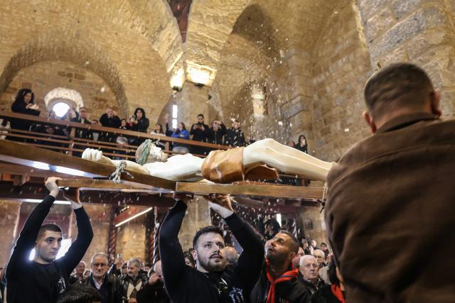 Lebanese Maronite Christians carry a large crucifix as they celebrate Good Friday in the southern border village of Qlayaa on April 3, 2026, amid the ongoing Middle East war. Lebanon was drawn into the Middle East war on March 2 when the Tehran-backed Hezbollah launched rockets at Israel to avenge the US-Israeli attack that killed Iran's supreme leader. Israel has responded with massive strikes across Lebanon as well as the ground operation. (Photo by AFP)