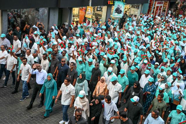 The Maldives’ President Mohamed Muizzu (L), along with First Lady Sajidha Mohamed and supporters of the People's National Congress (PNC), takes part in a campaign rally in Male on April 3, 2026 on the eve of the local council elections as well as a referendum on a controversial constitutional amendment. (Photo by Mohamed Afrah / AFP)