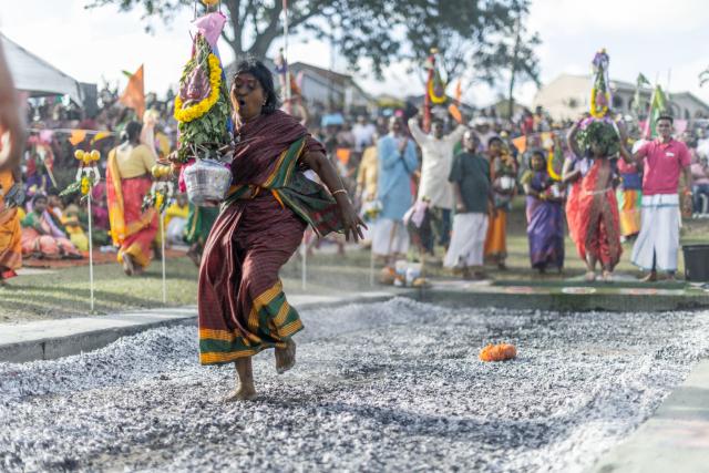 A Hindu devotee walks across a 15 metre long burning pit of hot coals during the Firewalking or “Thimithi” festival, celebrating Draupadi, considered as the incarnation of Hindu Goddess Mariamman, in Durban on April 3, 2026. Thimithi is practice where devotees walk barefoot over a bed of hot coals or embers as a form of religious devotion or ritual. It’s often performed as a test of faith, a rite of passage, or a way to seek blessings from a deity. (Photo by RAJESH JANTILAL / AFP)