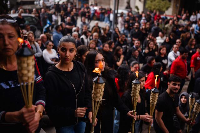 Lebanese Maronite Christian scouts hold torches during a Good Friday procession near the Saint Maroun Church in the Shiyah neighbourhood of Beirut's southeastern suburbs on April 3, 2026. Lebanon was drawn into the Middle East war on March 2 when Tehran-backed militant group Hezbollah launched attacks on Israel to avenge the killing of the Iranian leader. Israel has responded with broad strikes across Lebanon and a ground offensive. (Photo by Dimitar DILKOFF / AFP)
