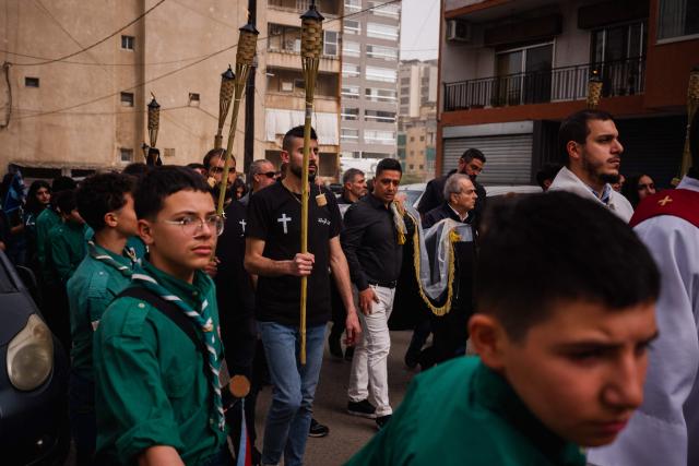Lebanese Maronite Christian worshippers attend a Good Friday procession near the Saint Maroun Church in the Shiyah neighbourhood of Beirut's southeastern suburbs on April 3, 2026. Lebanon was drawn into the Middle East war on March 2 when Tehran-backed militant group Hezbollah launched attacks on Israel to avenge the killing of the Iranian leader. Israel has responded with broad strikes across Lebanon and a ground offensive. (Photo by Dimitar DILKOFF / AFP)