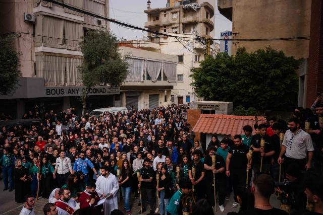Lebanese Maronite Christian worshippers attend a Good Friday procession near the Saint Maroun Church in the Shiyah neighbourhood of Beirut's southeastern suburbs on April 3, 2026. Lebanon was drawn into the Middle East war on March 2 when Tehran-backed militant group Hezbollah launched attacks on Israel to avenge the killing of the Iranian leader. Israel has responded with broad strikes across Lebanon and a ground offensive. (Photo by Dimitar DILKOFF / AFP)