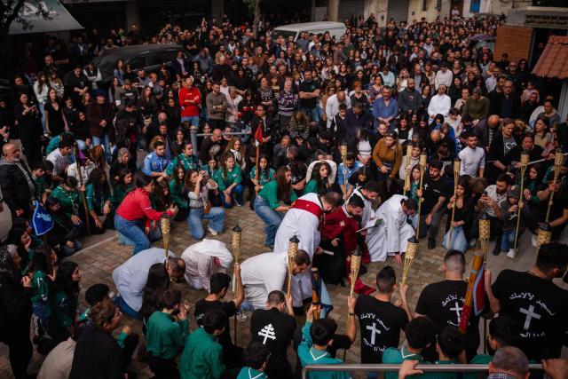 Lebanese Maronite Christian worshippers attend a Good Friday procession service in front of the Saint Maroun Church in the Shiyah neighbourhood of Beirut's southeastern suburbs on April 3, 2026. Lebanon was drawn into the Middle East war on March 2 when Tehran-backed militant group Hezbollah launched attacks on Israel to avenge the killing of the Iranian leader. Israel has responded with broad strikes across Lebanon and a ground offensive. (Photo by Dimitar DILKOFF / AFP)