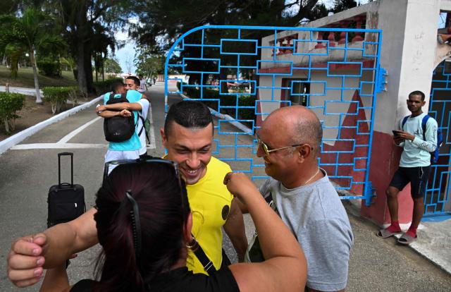Inmates embrace relatives as they walk free from La Lima prison in Havana on April 3, 2026. Cuban authorities began to free prisoners on April 3, 2026, after announcing it would pardon 2,010 inmates, the second release in less than a month as it faces heightened US pressure. (Photo by YAMIL LAGE / AFP)