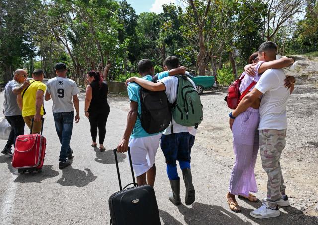 Inmates embrace relatives as they walk free from La Lima prison in Havana on April 3, 2026. Cuban authorities began to free prisoners on April 3, 2026, after announcing it would pardon 2,010 inmates, the second release in less than a month as it faces heightened US pressure. (Photo by YAMIL LAGE / AFP)