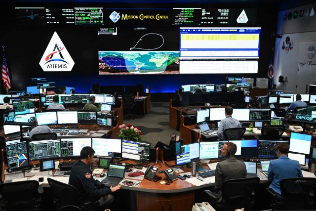 Artemis II controllers monitor the progress of the Orion spacecraft in the White Flight Control Room at Johnson Space Center in Houston, Texas, on April 3, 2026. Four Artemis astronauts were zooming towards the Moon late April 2 after a major engine firing, a milestone that commits NASA to the first crewed lunar flyby in more than half a century. With enough thrust to accelerate a stationary car to highway driving speed in less than three seconds, the Orion capsule engine blasted the astronauts on their trajectory towards the Moon, which they now will loop as part of the 10-day Artemis II mission. (Photo by RONALDO SCHEMIDT / AFP)