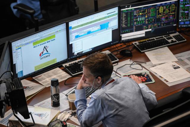 An Artemis II controller monitors the progress of the Orion spacecraft in the White Flight Control Room at Johnson Space Center in Houston, Texas, on April 3, 2026. Four Artemis astronauts were zooming towards the Moon late April 2 after a major engine firing, a milestone that commits NASA to the first crewed lunar flyby in more than half a century. With enough thrust to accelerate a stationary car to highway driving speed in less than three seconds, the Orion capsule engine blasted the astronauts on their trajectory towards the Moon, which they now will loop as part of the 10-day Artemis II mission. (Photo by RONALDO SCHEMIDT / AFP)