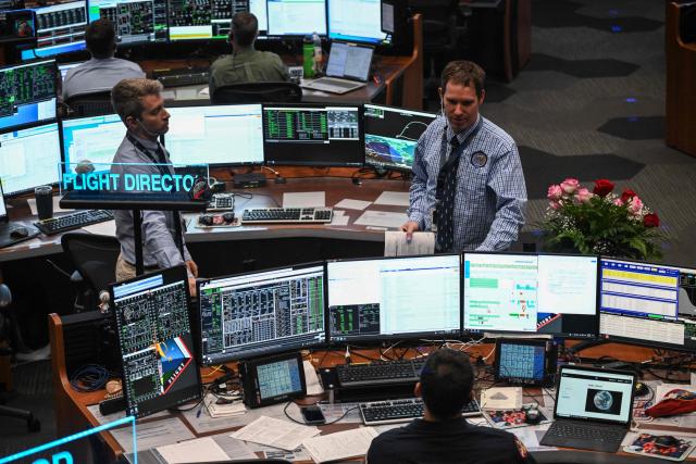 Artemis II controllers monitor the progress of the Orion spacecraft in the White Flight Control Room at Johnson Space Center in Houston, Texas, on April 3, 2026. Four Artemis astronauts were zooming towards the Moon late April 2 after a major engine firing, a milestone that commits NASA to the first crewed lunar flyby in more than half a century. With enough thrust to accelerate a stationary car to highway driving speed in less than three seconds, the Orion capsule engine blasted the astronauts on their trajectory towards the Moon, which they now will loop as part of the 10-day Artemis II mission. (Photo by RONALDO SCHEMIDT / AFP)