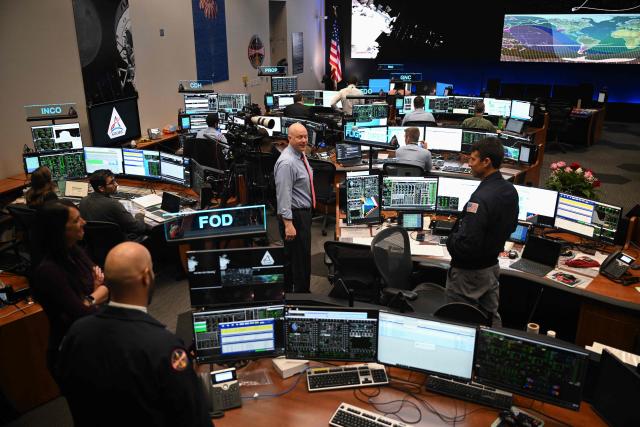 Artemis II controllers monitor the progress of the Orion spacecraft in the White Flight Control Room at Johnson Space Center in Houston, Texas, on April 3, 2026. Four Artemis astronauts were zooming towards the Moon late April 2 after a major engine firing, a milestone that commits NASA to the first crewed lunar flyby in more than half a century. With enough thrust to accelerate a stationary car to highway driving speed in less than three seconds, the Orion capsule engine blasted the astronauts on their trajectory towards the Moon, which they now will loop as part of the 10-day Artemis II mission. (Photo by RONALDO SCHEMIDT / AFP)