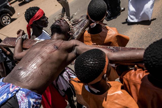 A man is tied to wooden cross during a re-enactment commemorating the crucifixion of Jesus Christ, in Bakoteh, The Gambia, on April 3, 2026. (Photo by MUHAMADOU BITTAYE / AFP)