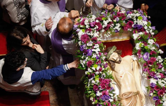 Alter boys and clergymen carry a statue representing the body of Jesus Christ after he was taken down the cross during the Good Friday mass at the Our Lady of Perpetual Help Chaldean Catholic Church in Arbil, the capital of the autonomous Kurdish region of northern Iraq, on April 3, 2026. (Photo by Safin HAMID / AFP)