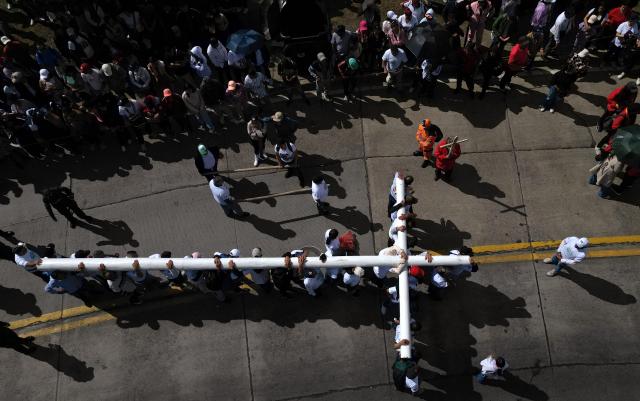 Aerial view of catholic faithfuls carrying a cross during the Via Crucis procession as part of Good Friday celebrations at the Tree of Life in Ciudad Bolivar, south Bogota on April 3, 2026. (Photo by Raul ARBOLEDA / AFP)